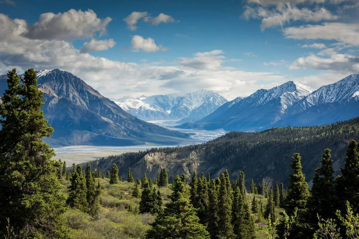 A sunlit mountain valley with distant peaks